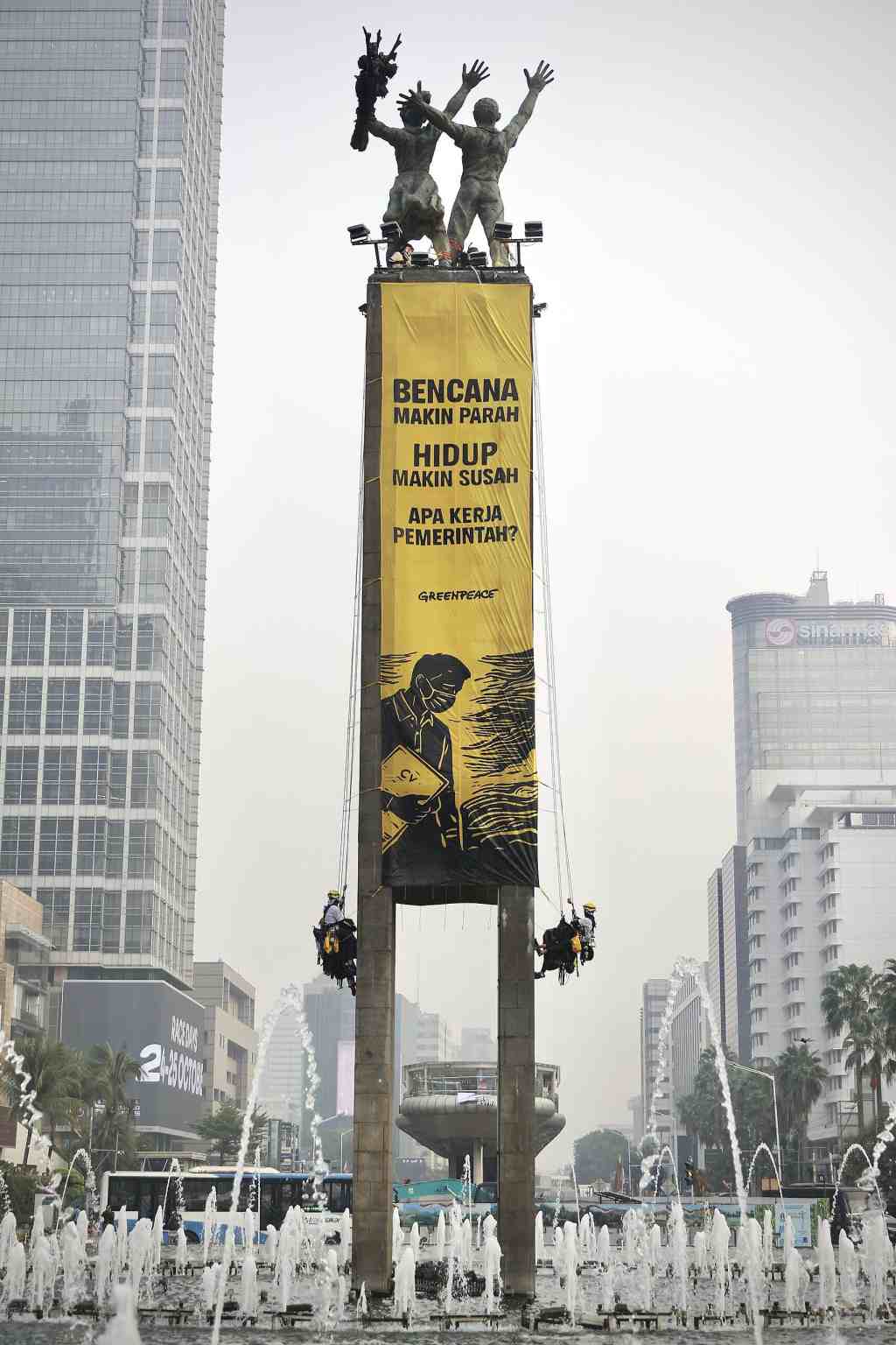 Aktivis Greenpeace Indonesia menyuarakan desakan penanganan krisis iklim dan penurunan beban biaya hidup di Bundaran HI.